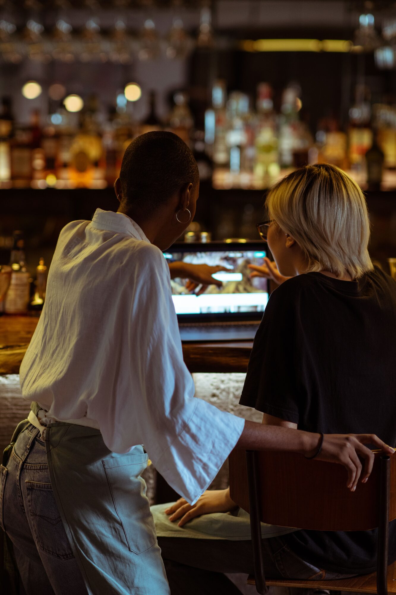 Dos personas del equipo en la barra, mirando juntas una pantalla